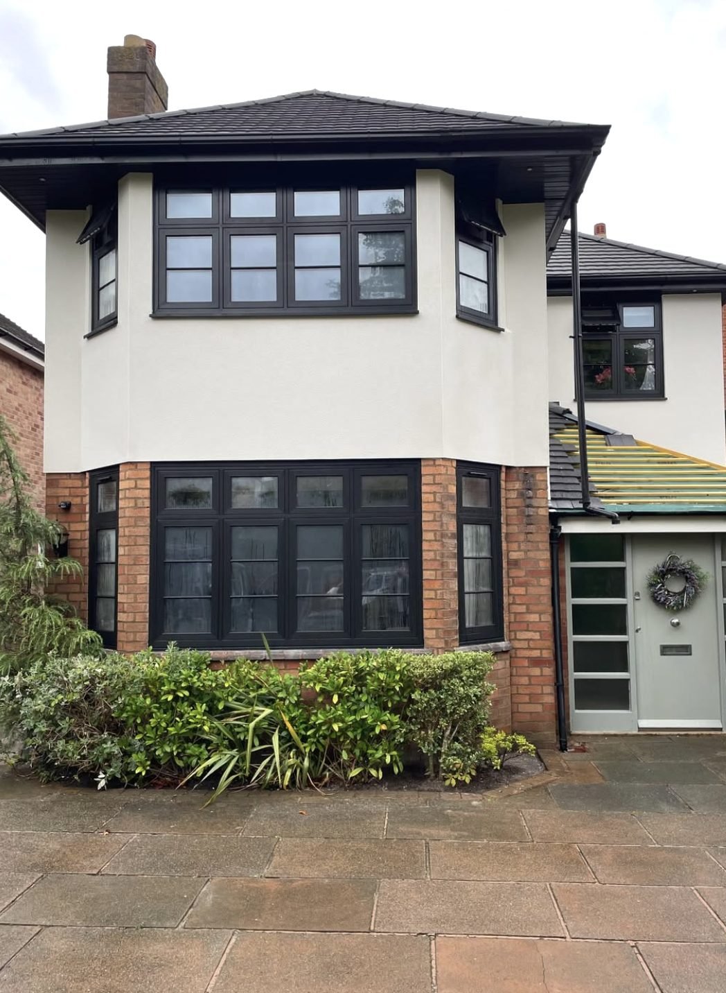 Semi-detached house with a rendered first-floor bay above a brick ground floor