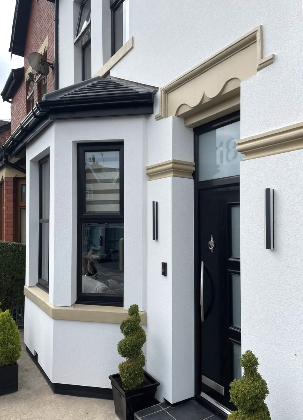 White rendered bay and entrance with a cream door surround and band
